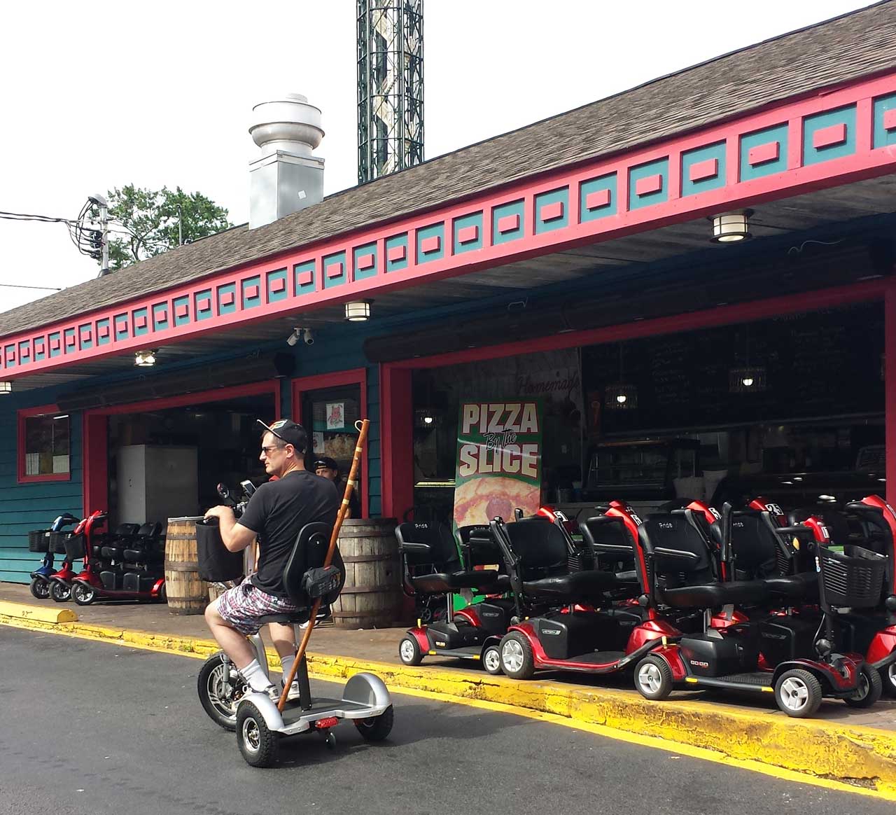 The Triad driving past a sea of traditional scooters. Notice the seat height of the Triad.